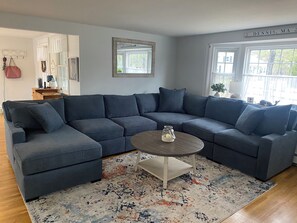 A modern living room with a sectional sofa, a round coffee table, and a patterned rug.