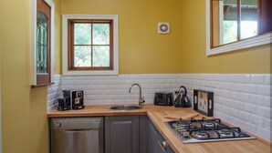 A compact kitchen with a dishwasher, sink, and stove.
