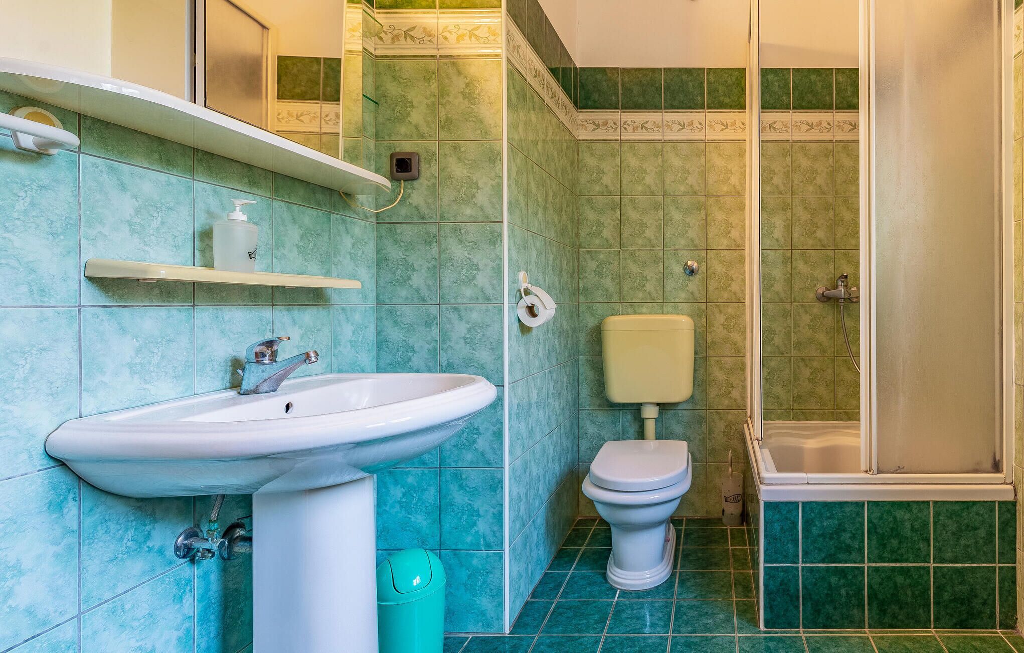 A bathroom with a sink, toilet, and shower.