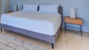A modern bedroom with a bed, bedside tables, and a nightstand. - CONDO 57 BY TRVL2HM (Puerto Vallarta)
