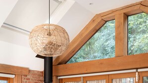 Un salon chaleureux avec une cheminée, un canapé confortable et une grande fenêtre donnant sur un paysage verdoyant.