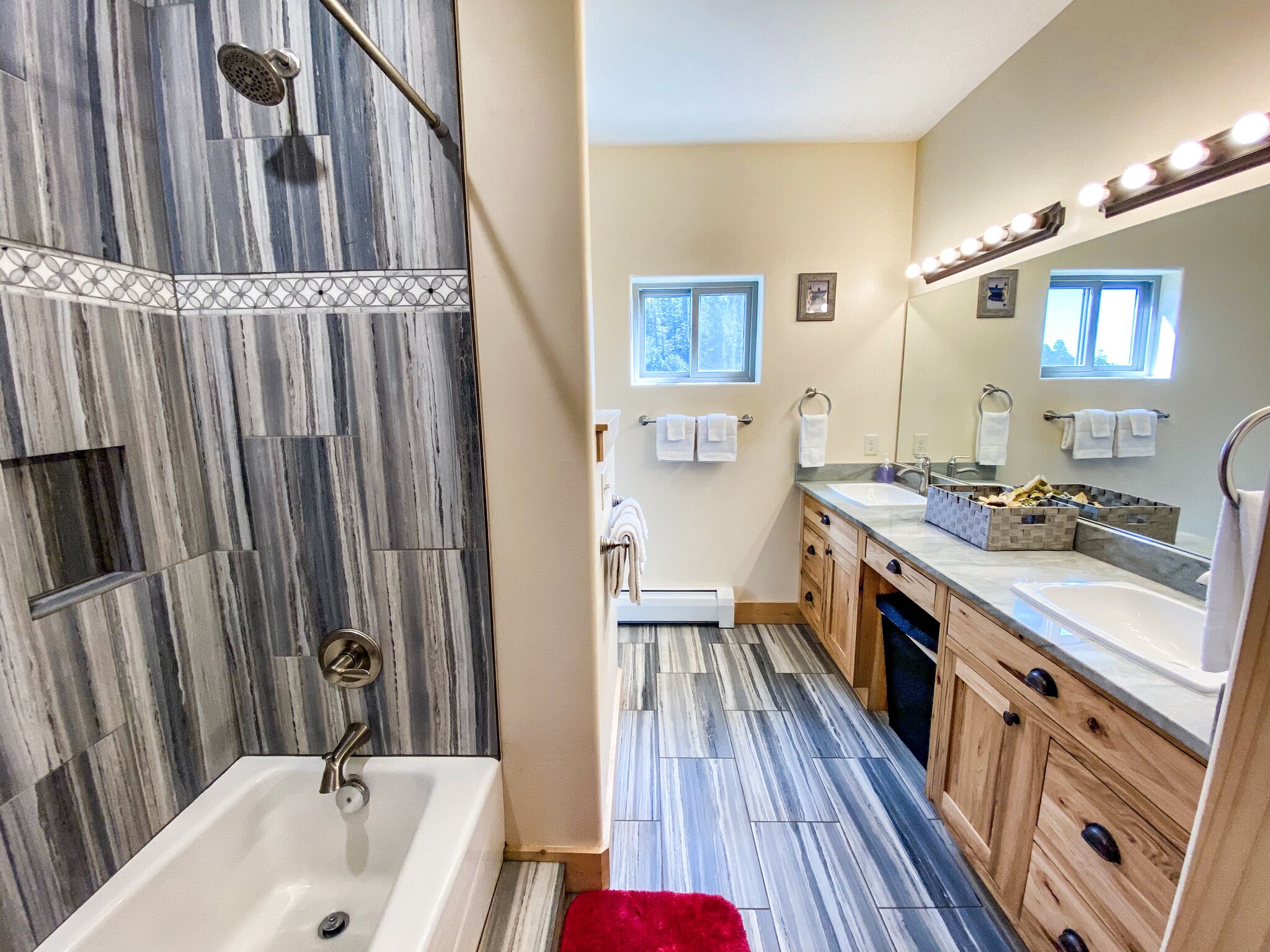A modern bathroom with a shower, a bathtub, a vanity with a sink, and a large mirror.