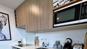 Una cocina moderna con armarios de madera, microondas, tostadora y hervidor.