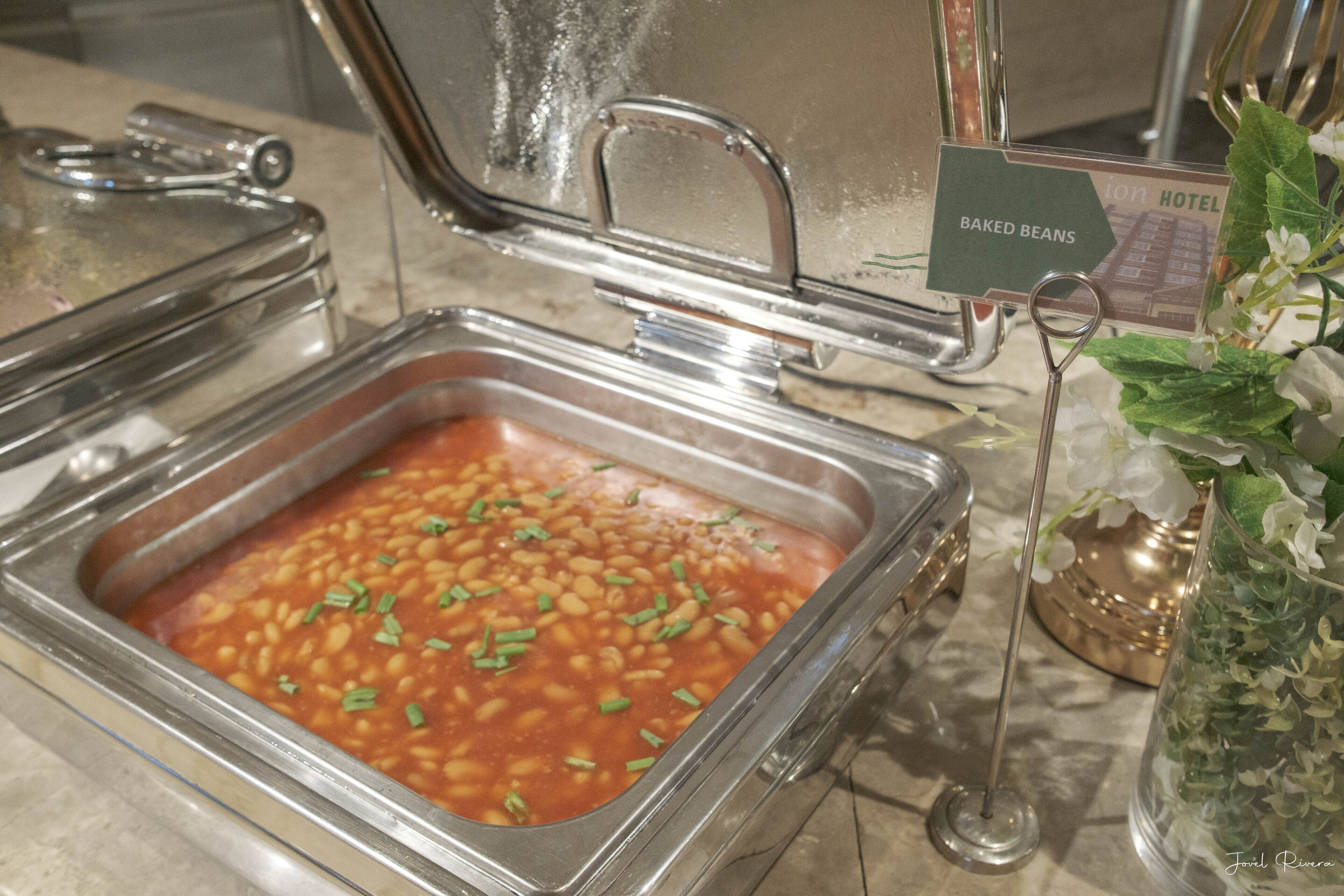 A buffet area with baked beans and a sign for the Bison Hotel.