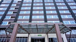 A multi-story hotel with a modern facade, large windows, and a prominent entrance with a glass canopy. - Ion Hotel (Baguio)