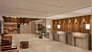 A spacious lobby with a reception desk, seating area, and a view into a restaurant. - Ion Hotel (Baguio)