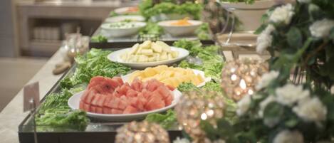 Una mesa de buffet con diversos alimentos y elementos decorativos.