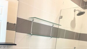 A bathroom with a toilet, sink, glass shower enclosure, and a towel rack. - *NEW* Casita Lalita -  2bd/2.5 ba condo - 5 mins to beach w/ 200mbps wifi + pool (Tamarindo)