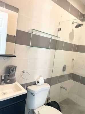 A bathroom with a toilet, sink, glass shower enclosure, and a towel rack. - *NEW* Casita Lalita -  2bd/2.5 ba condo - 5 mins to beach w/ 200mbps wifi + pool (Tamarindo)