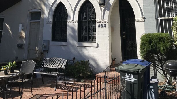 Un edificio bianco con tre finestre ad arco e un ingresso, numero 802.
