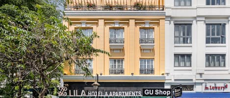 A hotel with a GU Shop and a LILA Hotel & Apartments sign.