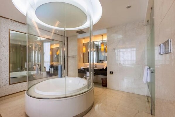 Une salle de bain moderne avec une grande baignoire, une douche à l’italienne et un miroir.