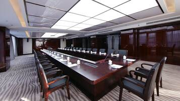 A conference room with a long table, chairs, microphones, and nameplates.