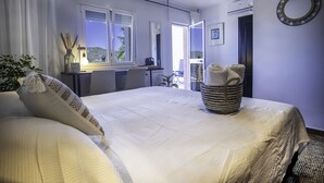 A bedroom with a large bed, a desk, and a view of the outdoors. - Malaga Hills, Adults Only boutique, wellness & hiking Eco-Hotel (Còmpeta)