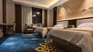 Ein Hotelzimmer mit Bett, Schreibtisch, Stuhl und einem großen Fenster.