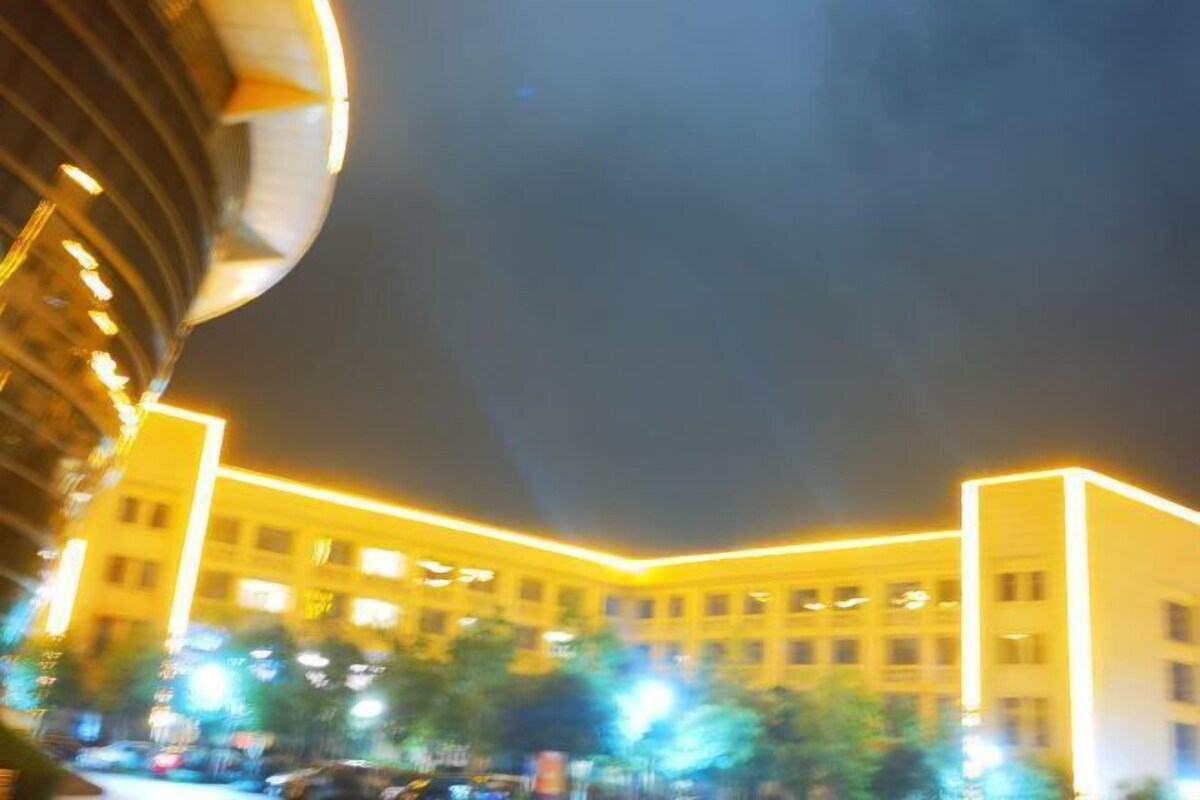 A building with multiple floors and a yellow-lit facade.
