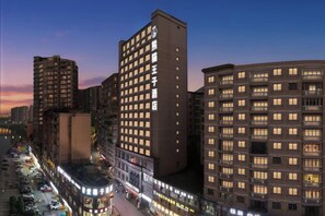 Ein mehrstöckiges Hotel mit modernem Design, das eine markante Eingangspartei und mehrere Balkone aufweist.
