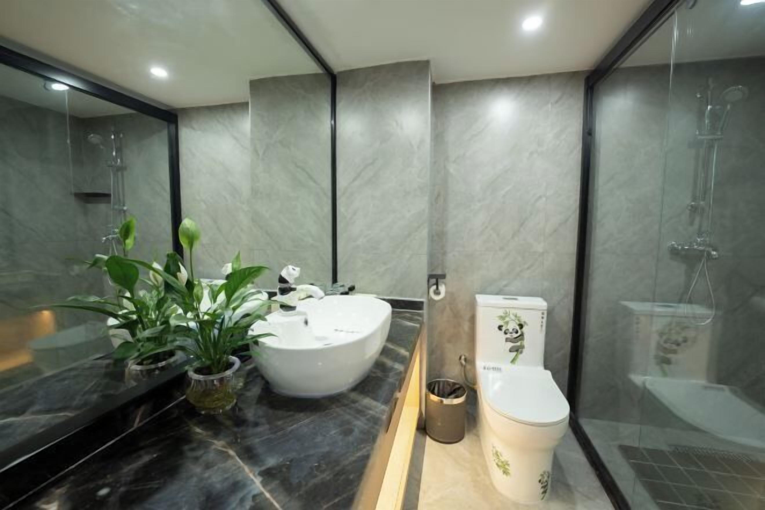 A modern bathroom with a large sink, toilet, and shower area.