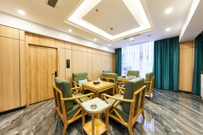 Een vergaderzaal met een ronde tafel en stoelen, houten lambrisering en uitzicht op het groen.