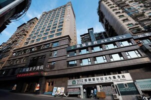 Un edificio de varios pisos con diversos comercios en la planta baja, incluyendo una farmacia y un centro de servicios de salud.