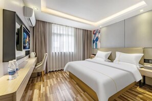 A modern hotel room with a large bed, a desk with a flat-screen TV, and a seating area with a chair. - Yimi Hotel (Guangzhou Xicun Subway Station) (Guangzhou)