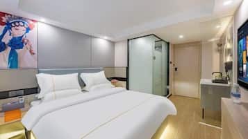 A modern hotel room with a large bed, a glass partition wall, and a flat-screen TV on a wooden console.