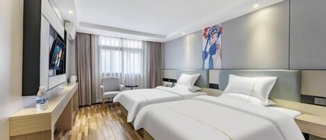 Quarto de hotel com duas camas, uma mesa, uma cadeira, uma televisão e um quadro na parede.