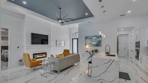 Ein modernes Wohnzimmer mit Kamin, Sofa und Deckenventilator.