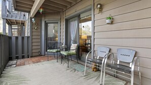 A covered porch with two metal chairs, a small table, and a potted plant. - Perfect Arizona Mountain Retreat (Payson)
