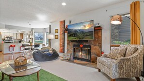 A modern living room with a fireplace, a large flat-screen TV, and a cozy seating area. - Perfect Arizona Mountain Retreat (Payson)