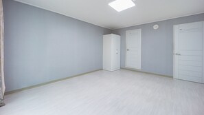 A room with a light grey wall, a white door, and a white wardrobe. - Sokcho World Pet-friendly Pension (Sokcho)