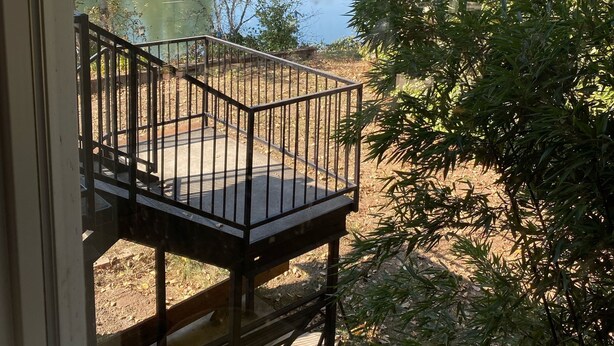 A deck with a metal railing overlooking a lake surrounded by trees. - Exotic Waterfront Getaway (Salem)