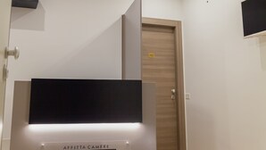 Un interior moderno con un letrero que dice "Isgro Rooms" y una lámpara colgante negra.