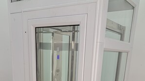Un ascensor moderno con puerta de cristal y panel de control.