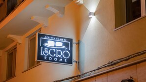 Un cartel que indica 'Affitta Cameri Isgro Rooms' en la fachada de un edificio.