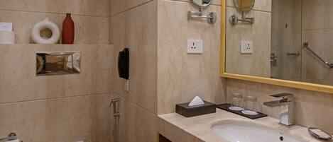 Un baño moderno con un espejo grande, dos lavamanos, un inodoro y una ducha.