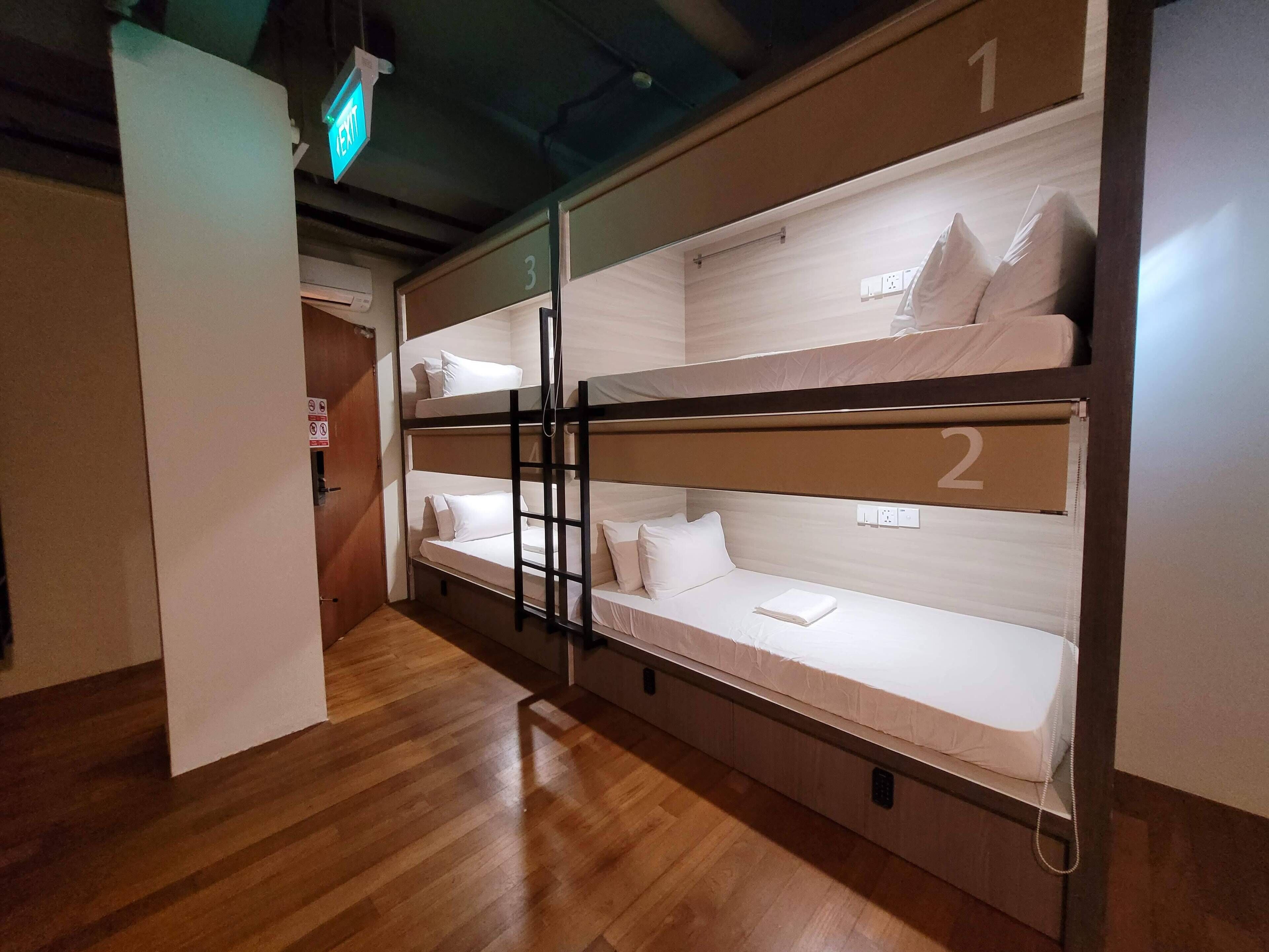 Een slaapkamer met een stapelbed van drie verdiepingen, elk voorzien van een nummer.