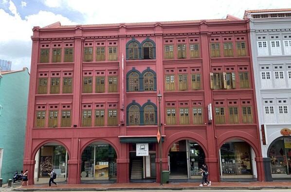 Un edificio de varios pisos con ventanas grandes y arcos en las entradas.