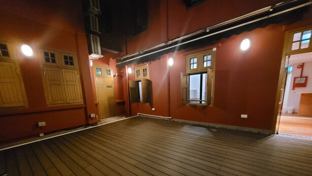 Una habitación con suelo de madera, una puerta y un ventanal.