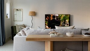 A modern living room with a grey sofa, a wooden coffee table, and a television mounted on the wall. - Design-Led- 2xSuper-King Beds- Ensuites- W Parking  (Eton)