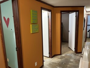 A hallway with two doors, one with a heart decoration, and motivational quotes on the wall. - A stone's throw from the River, this amazing property won't disappoint!   (Prairie du Chien)