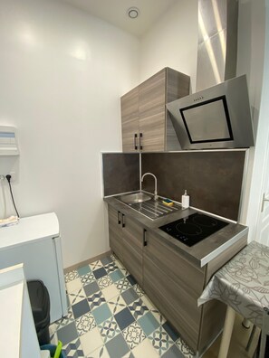 Una cocina compacta con estufa integrada, un lavabo y un microondas.