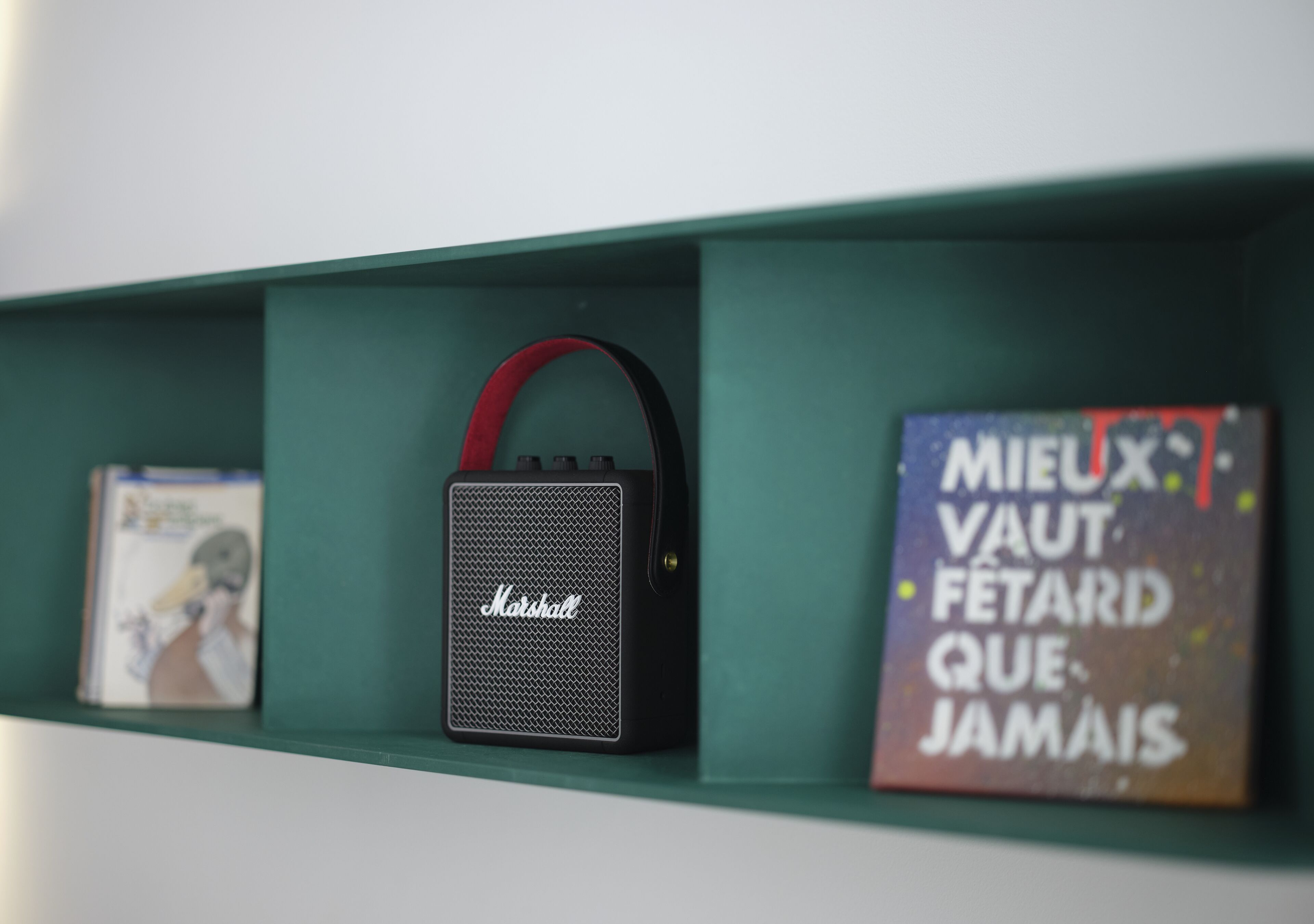 A shelf with a Marshall speaker and two books.