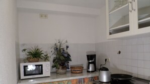 A kitchen with a microwave, coffee maker, and a stove.