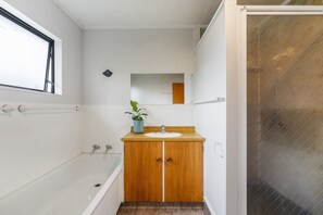 Bathtub, hair dryer, towels, toilet paper