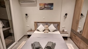 Ein Schlafzimmer mit Bett, Nachttisch, Kleiderschrank und einem Bild an der Wand.