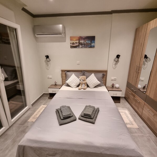 A bedroom with a bed, a nightstand, a wardrobe, and a painting on the wall.