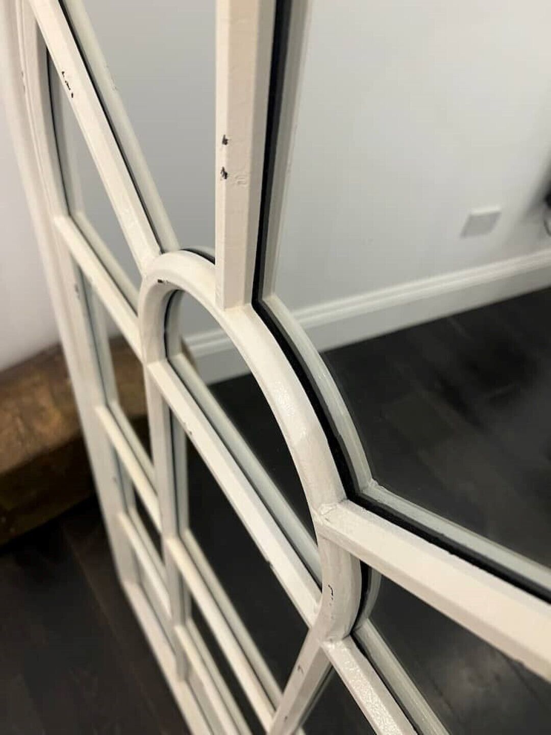 A close-up of a white metal frame with a geometric design, likely part of a window or door structure.