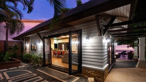 Ein modernes Haus mit Glastür und Eingang zu einem Essbereich mit Außenplätzen.