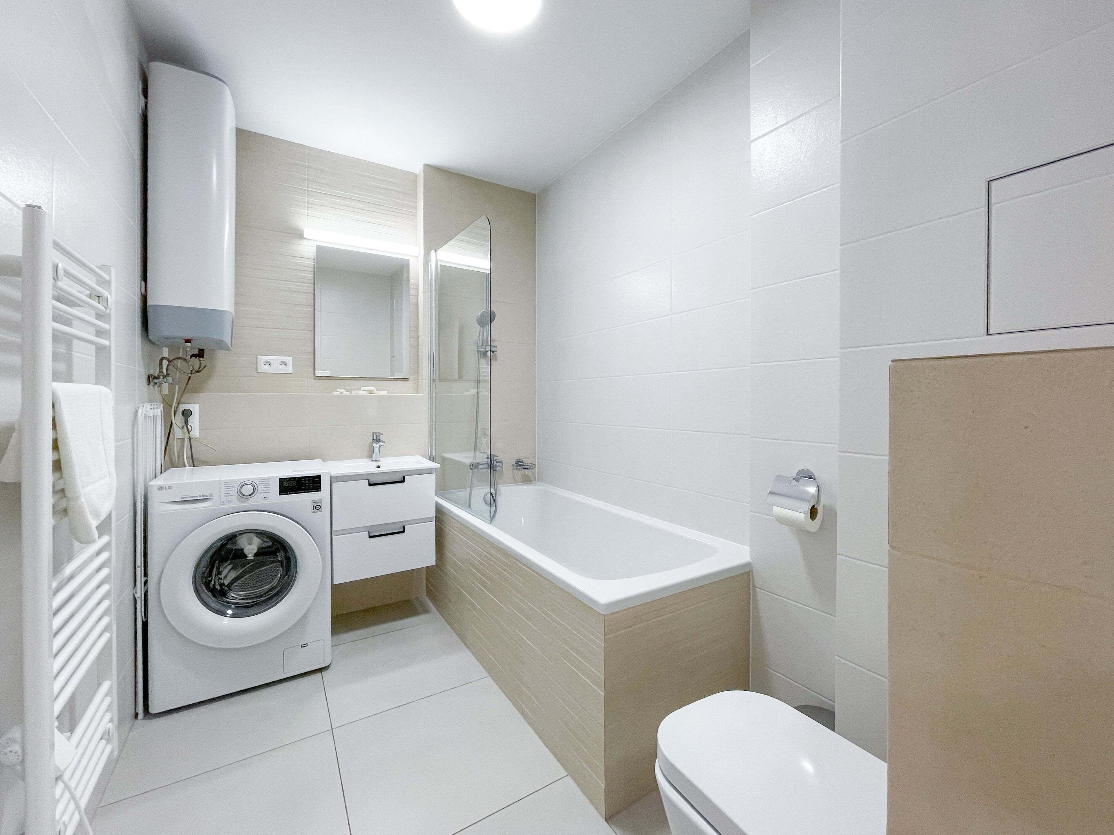 Un baño moderno con lavadora, bañera y retrete.